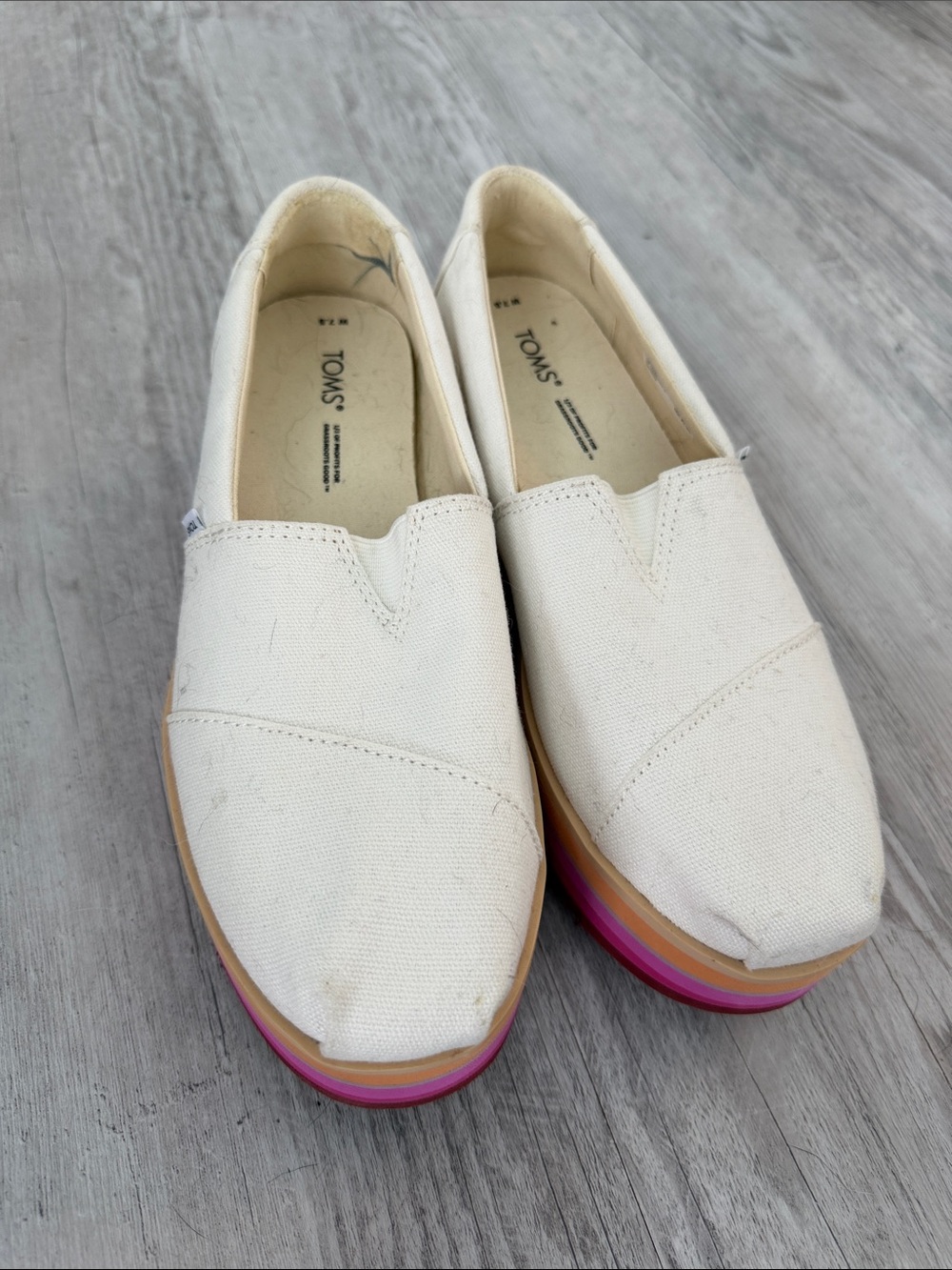 TOMS White Canvas Slip-Ons with Rainbow Accent Sole